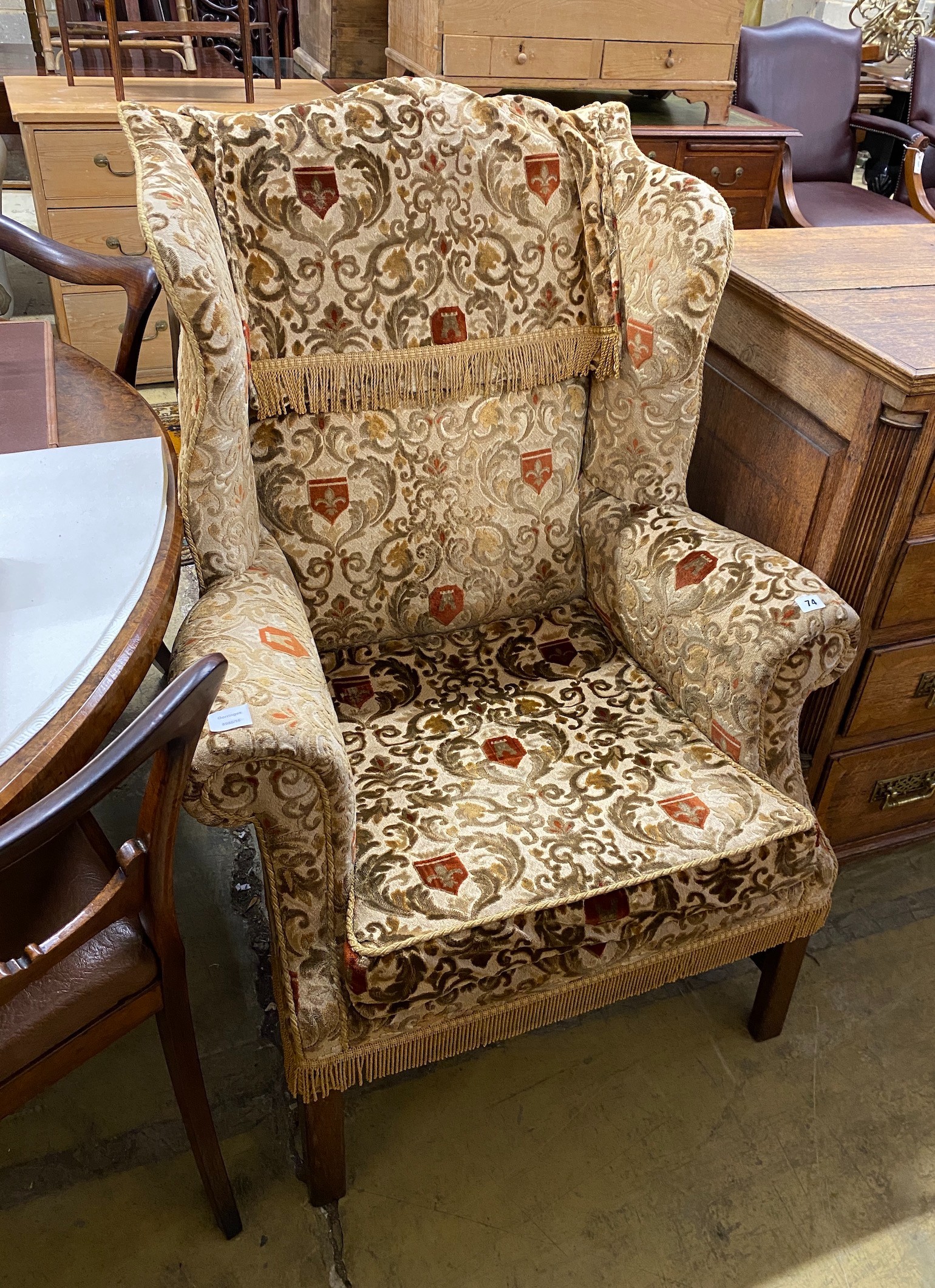 A George III style upholstered wing armchair, width 86cm, depth 70cm, height 112cm